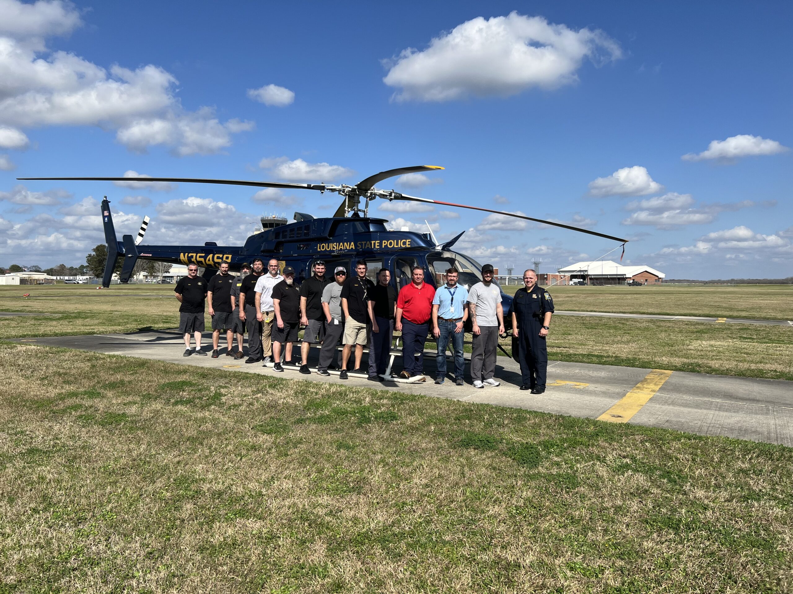 PHI MRO Services team stands in front of Louisiana State Police blue Bell 407 helicopter